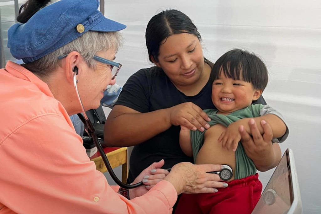 Olive Branch medical volunteer examining a child during a mission trip in Peru