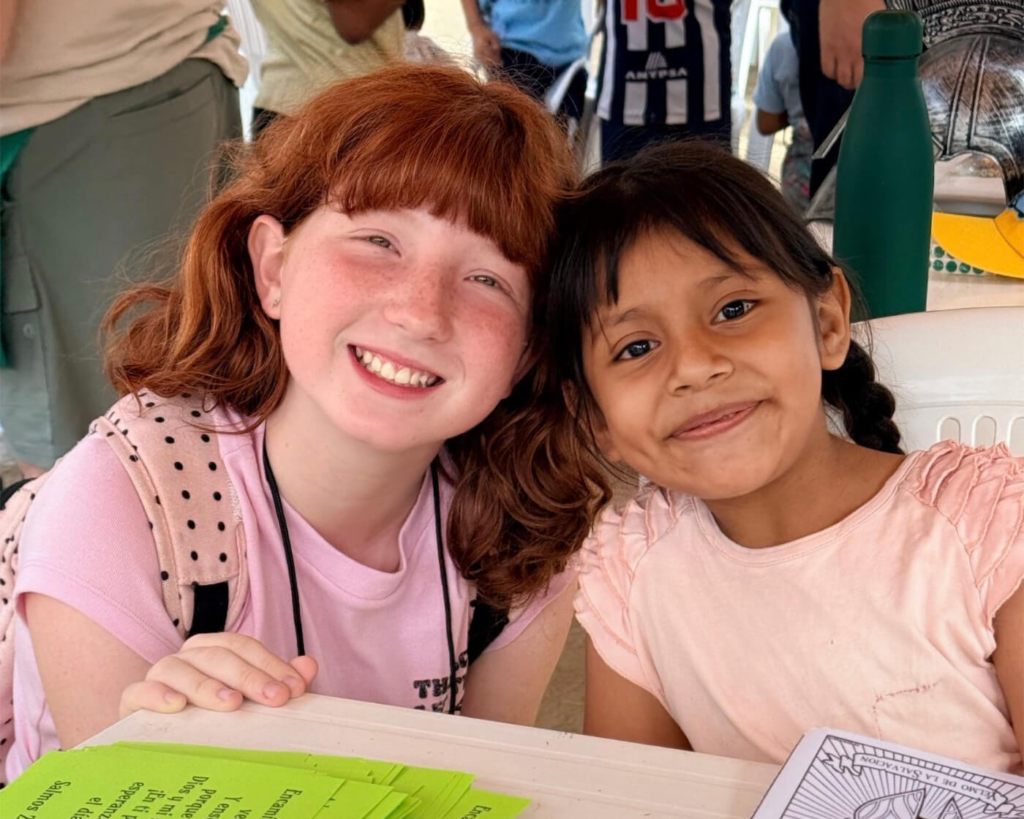 Two girls smile during a Vacation Bible School activity in Peru